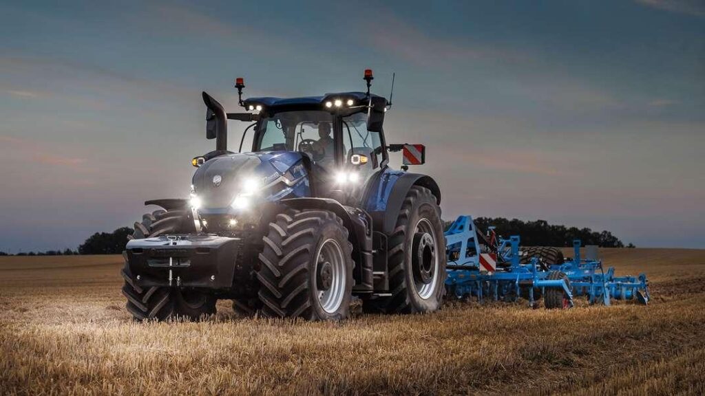 Buy Used Tractors. blue agricultural tractor driving across a harvested field.